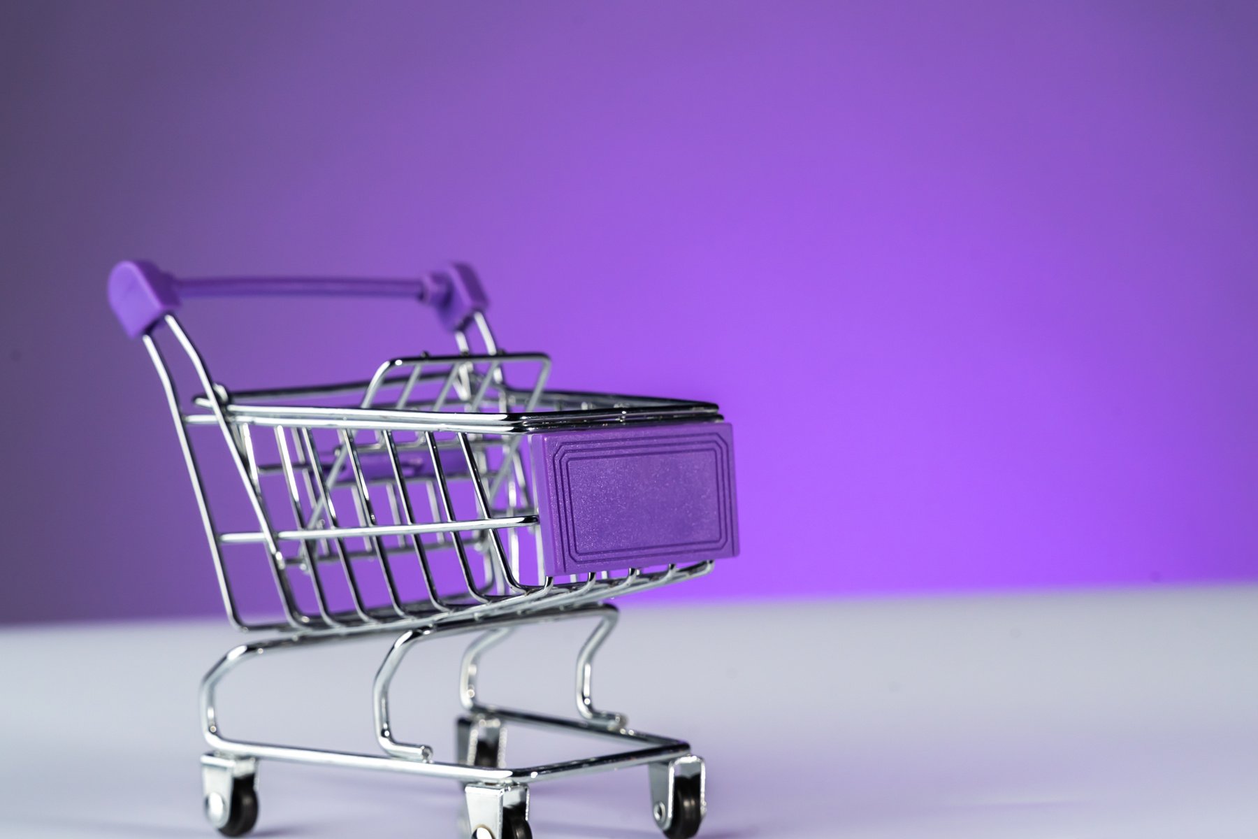 Close up retail shopping cart over purple background